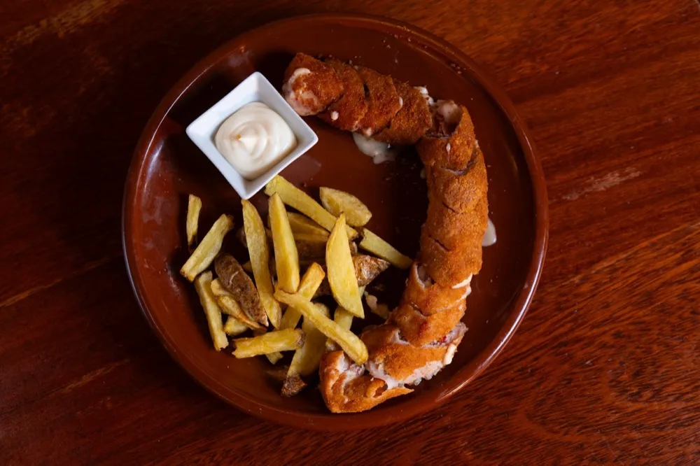 Flamenquín casero con patatas en Bodega Los Tintos