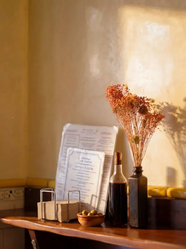 Pizarra de la carta y flores secas en Bodega Los Tintos
